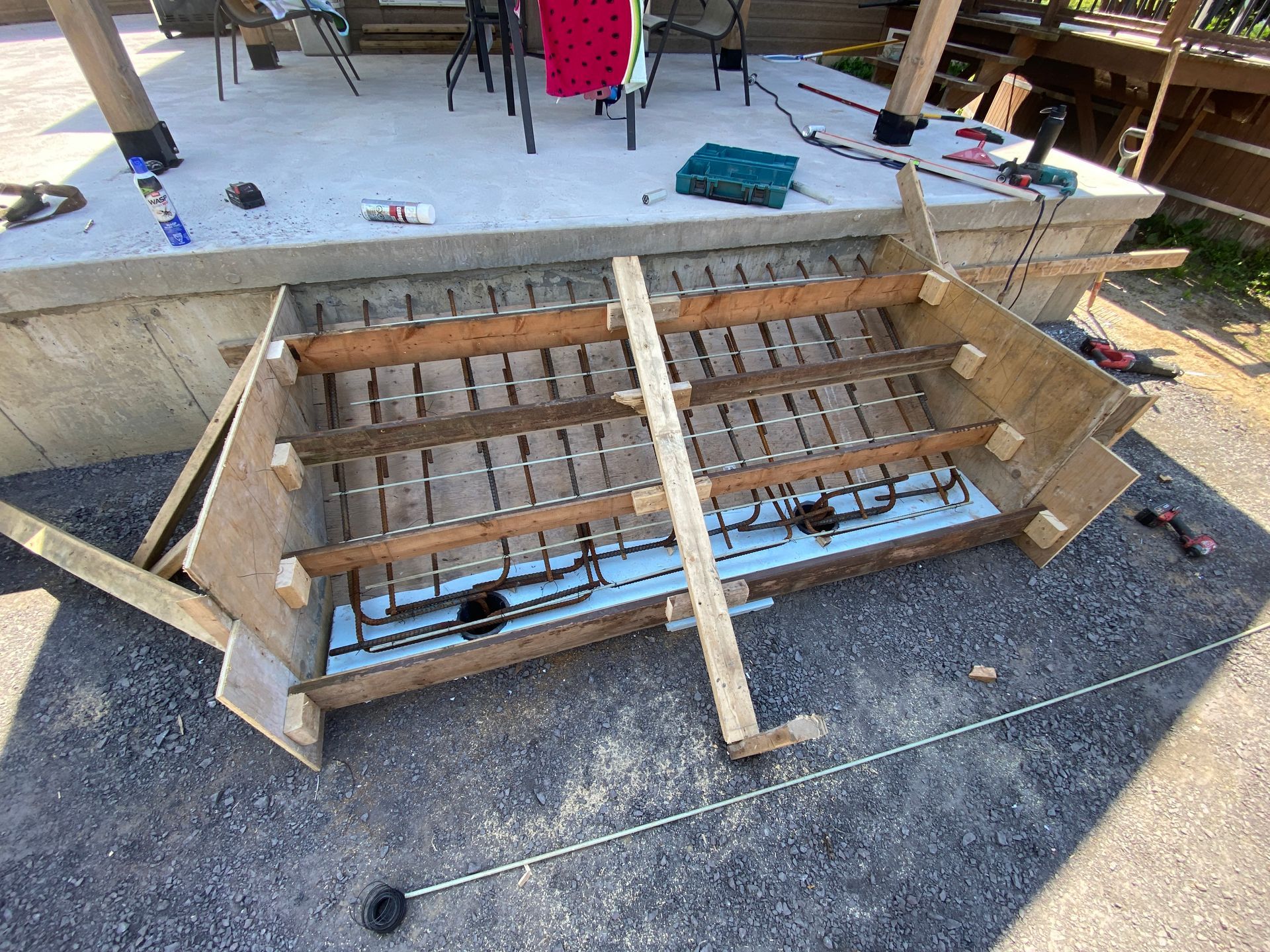 Un escalier en bois est en cours de construction sur une plateforme en béton.