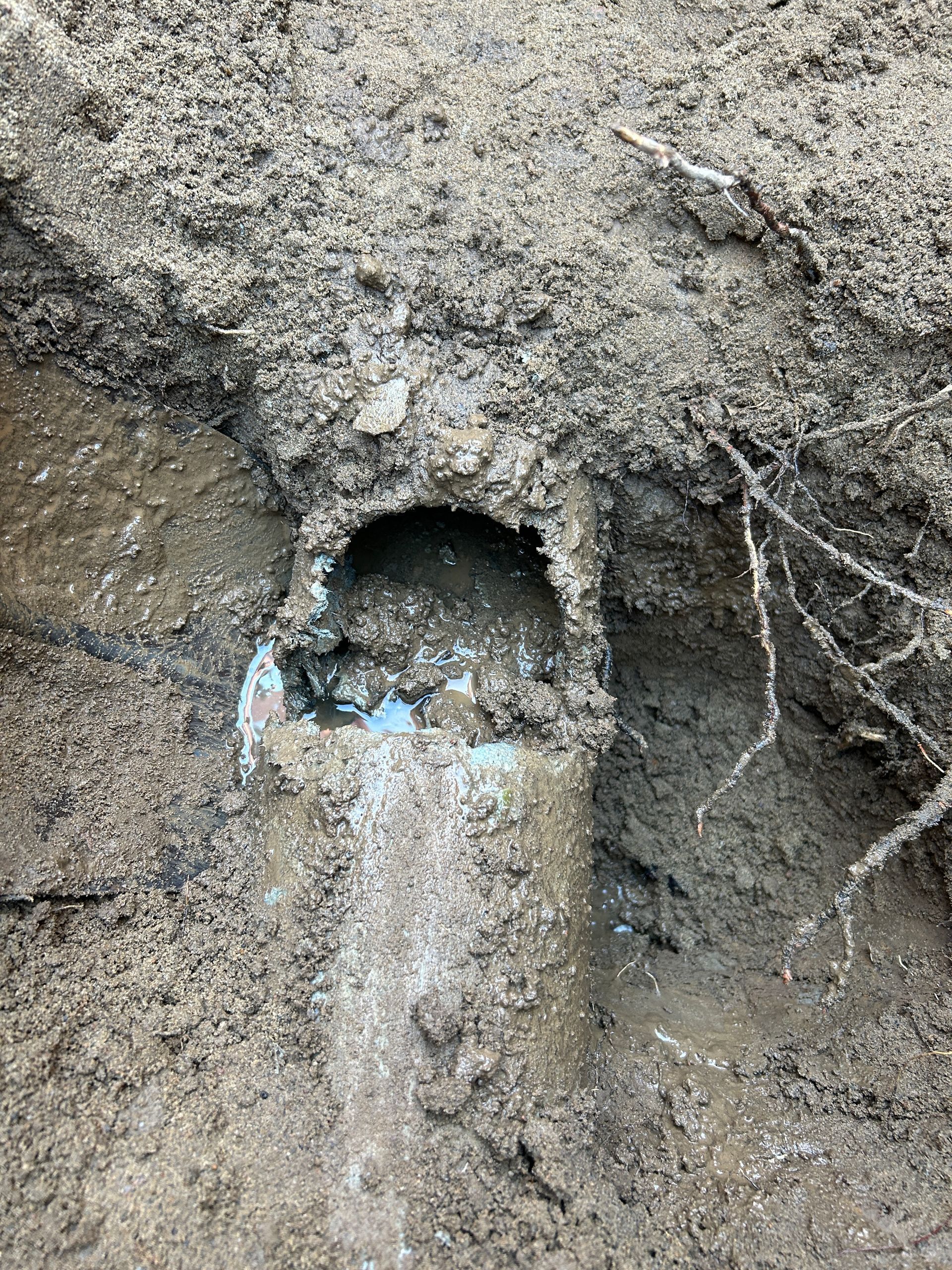 Un trou dans le sol d'où sort de l'eau.