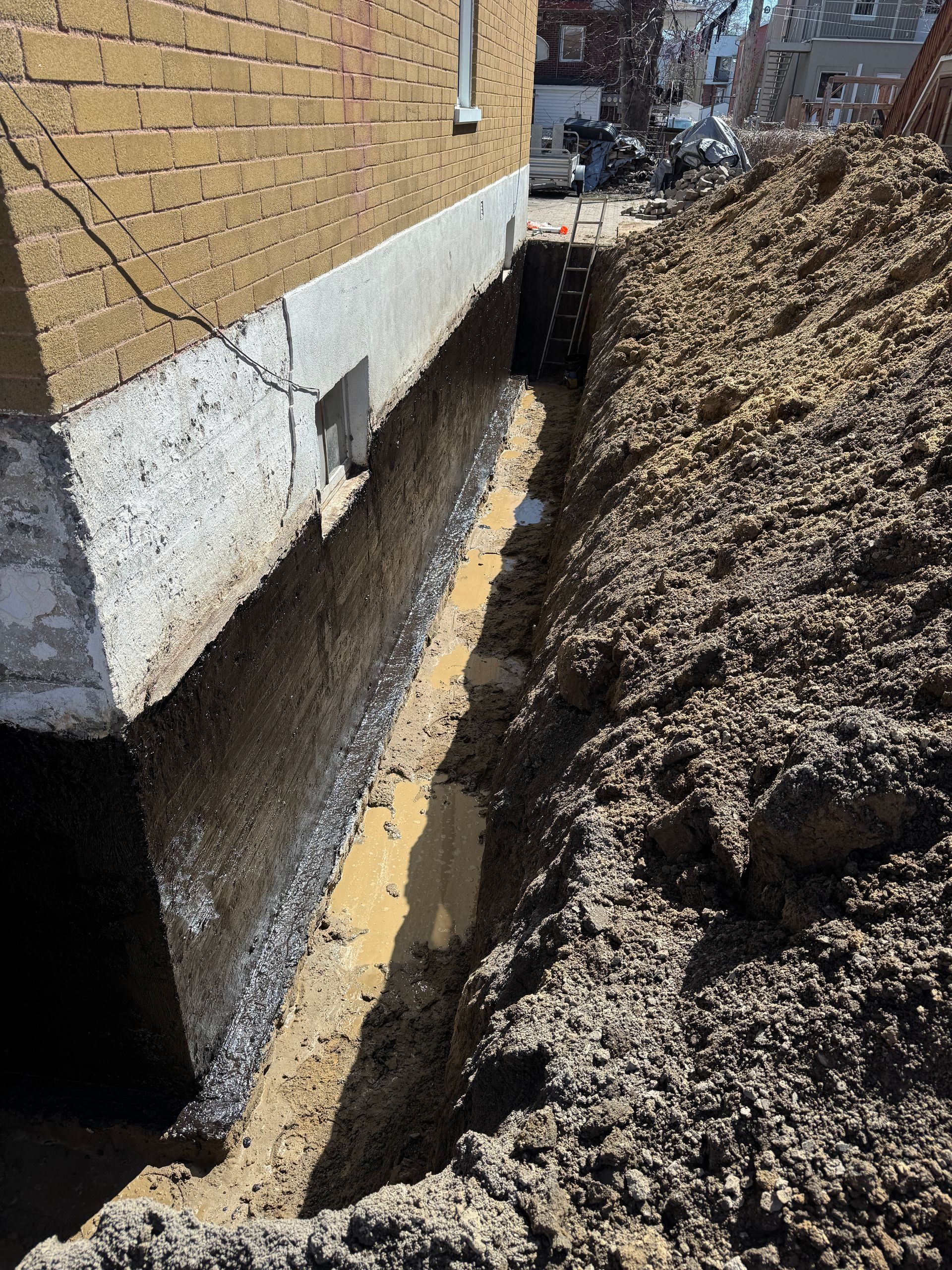Un gros tas de terre se trouve devant un bâtiment en briques.