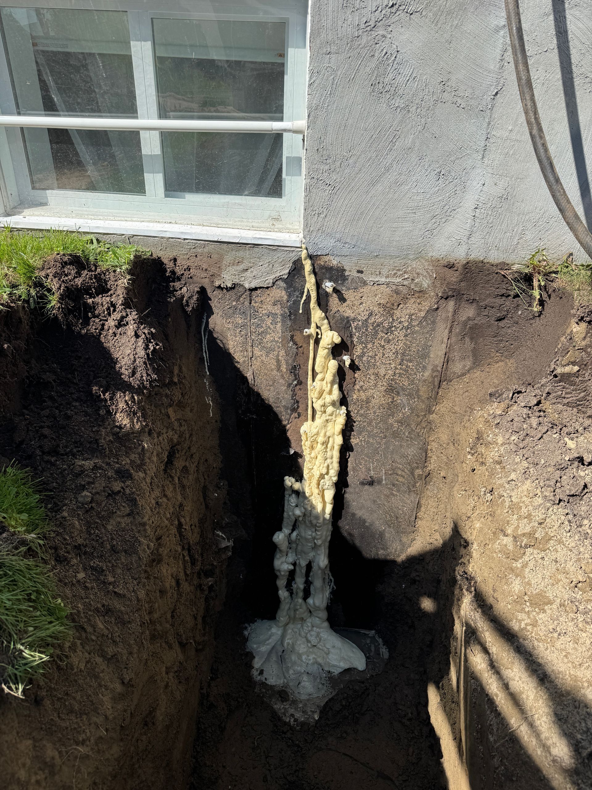 Un trou dans le sol avec une fenêtre en arrière-plan.
