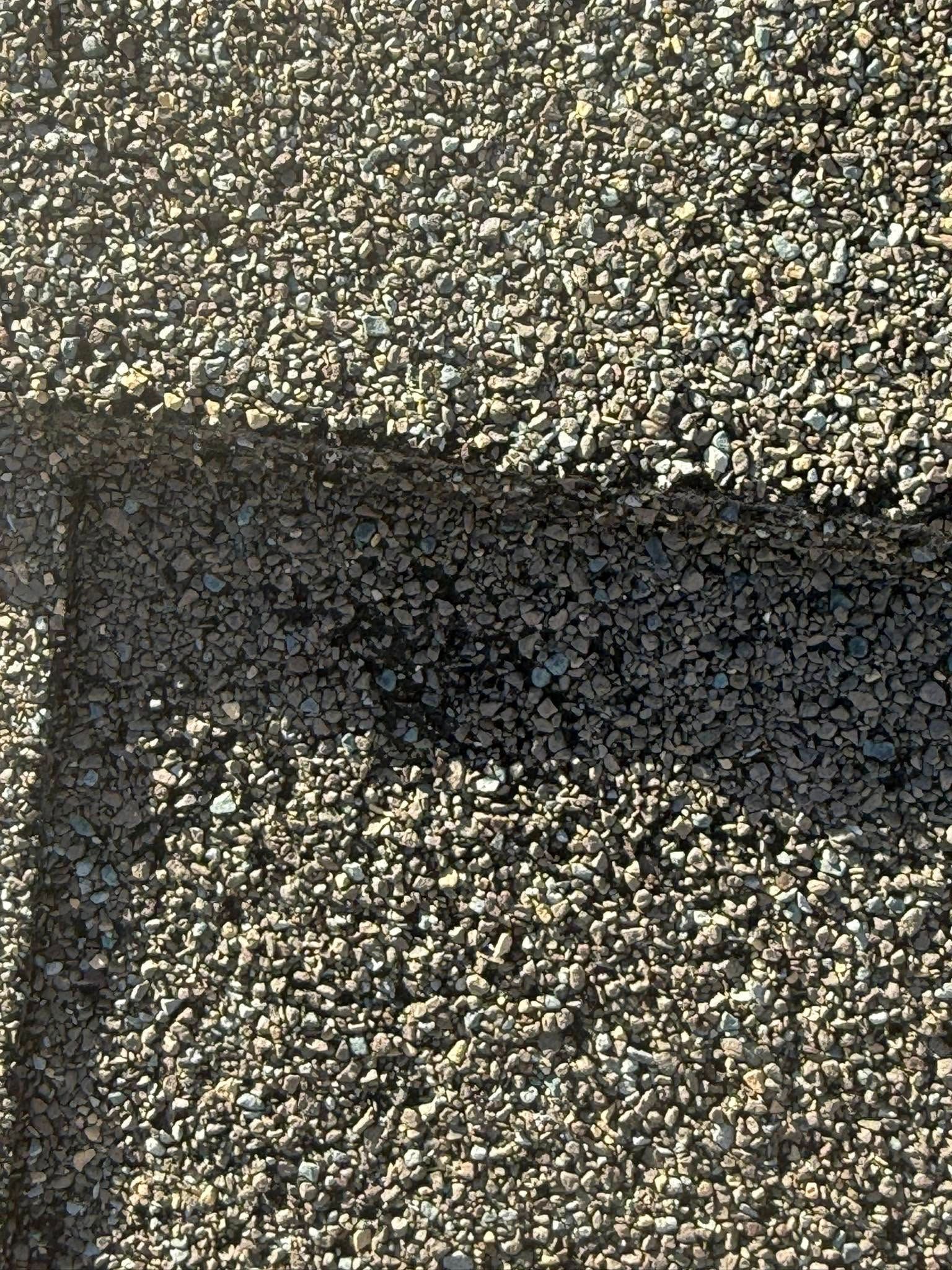 A close up of a roof with a lot of gravel on it.