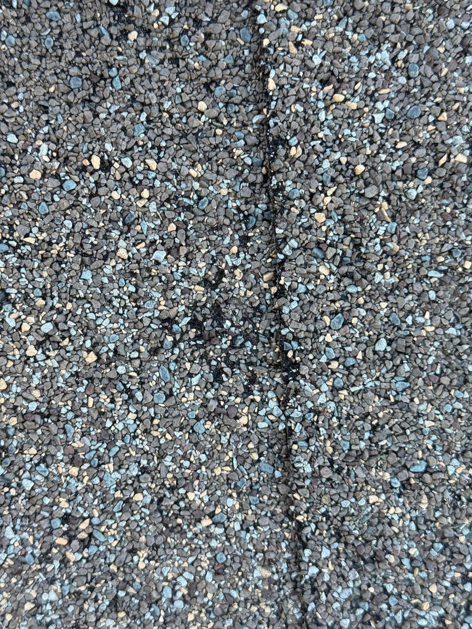 A close up of a roof with a lot of small rocks on it.