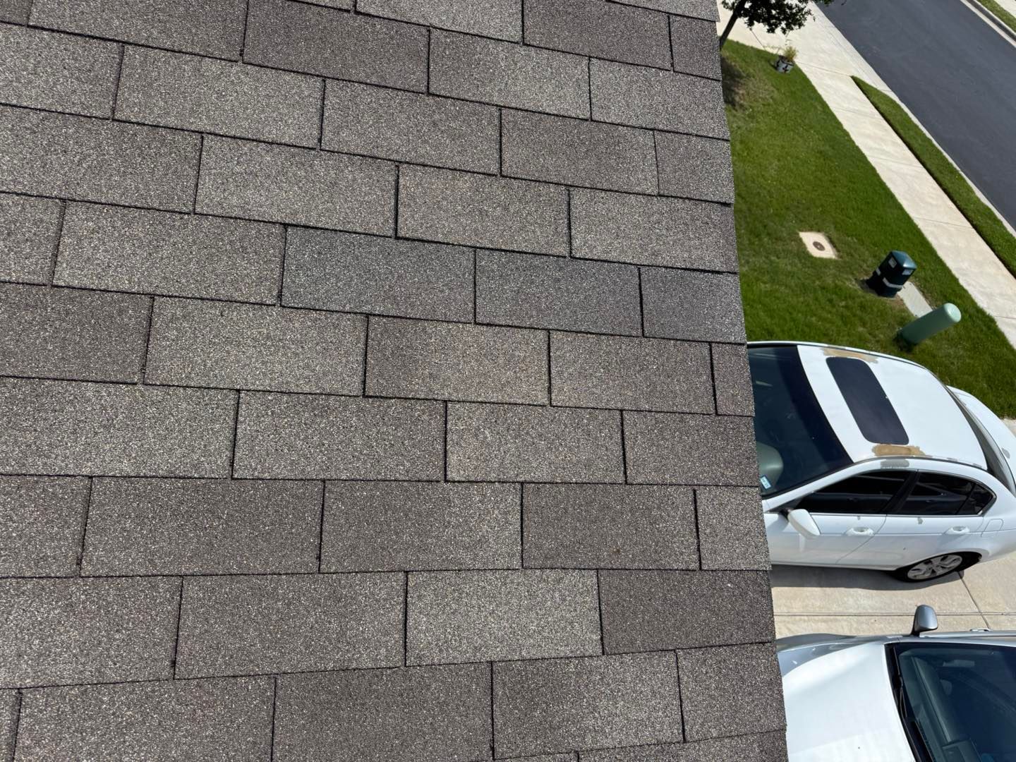 A white car is parked on the roof of a house.