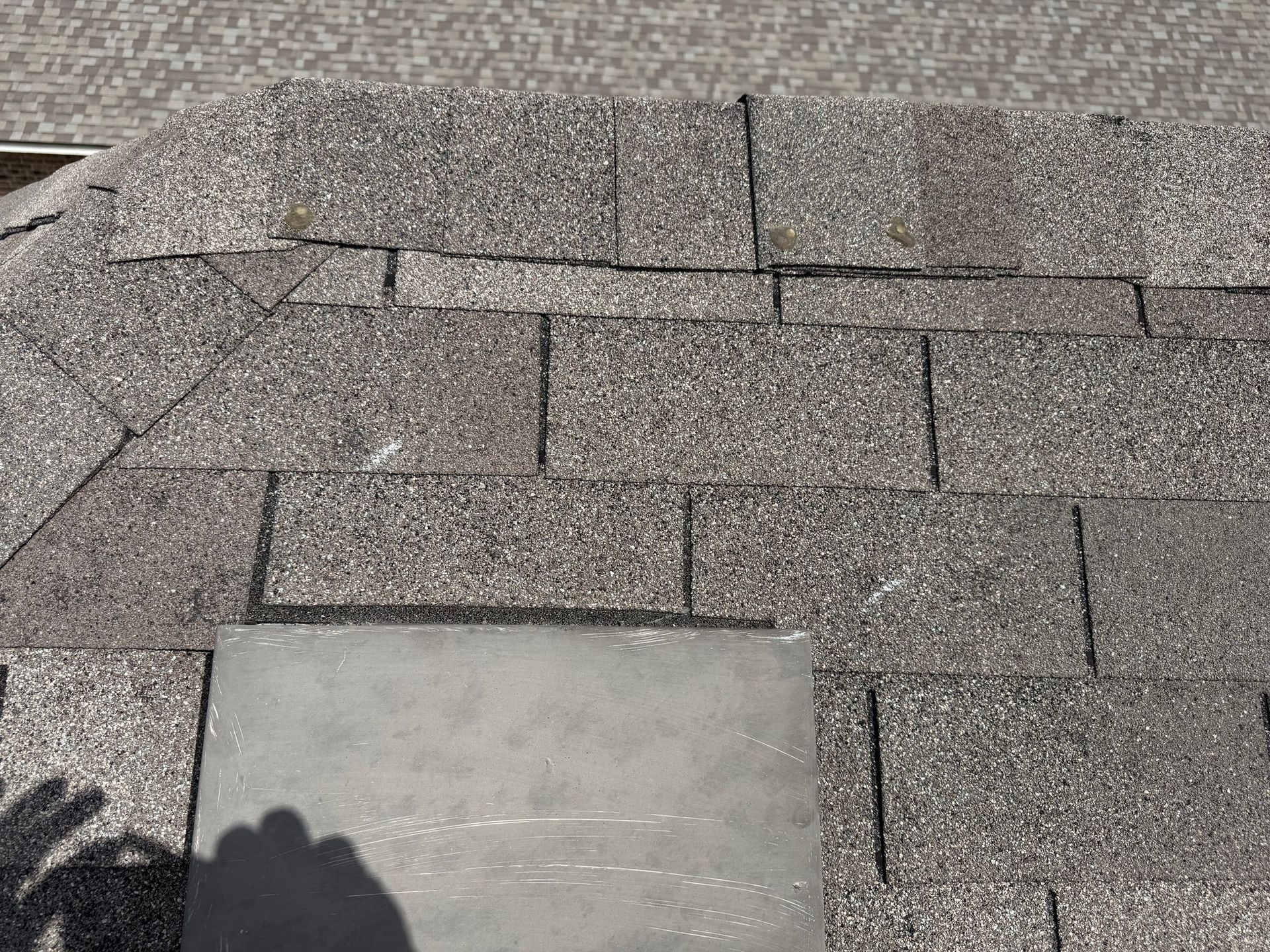 A close up of a roof with a shadow of a person on it.