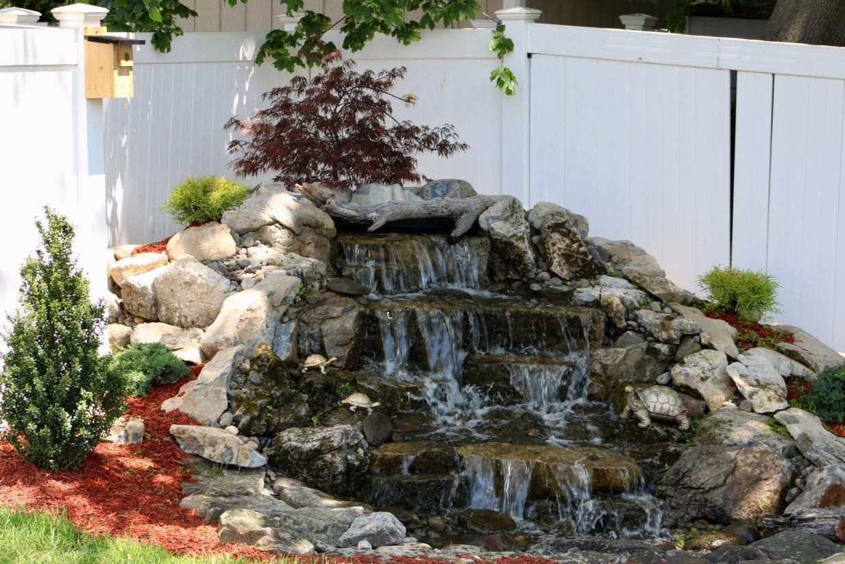 Water feature with cascading waterfall built of rocks.