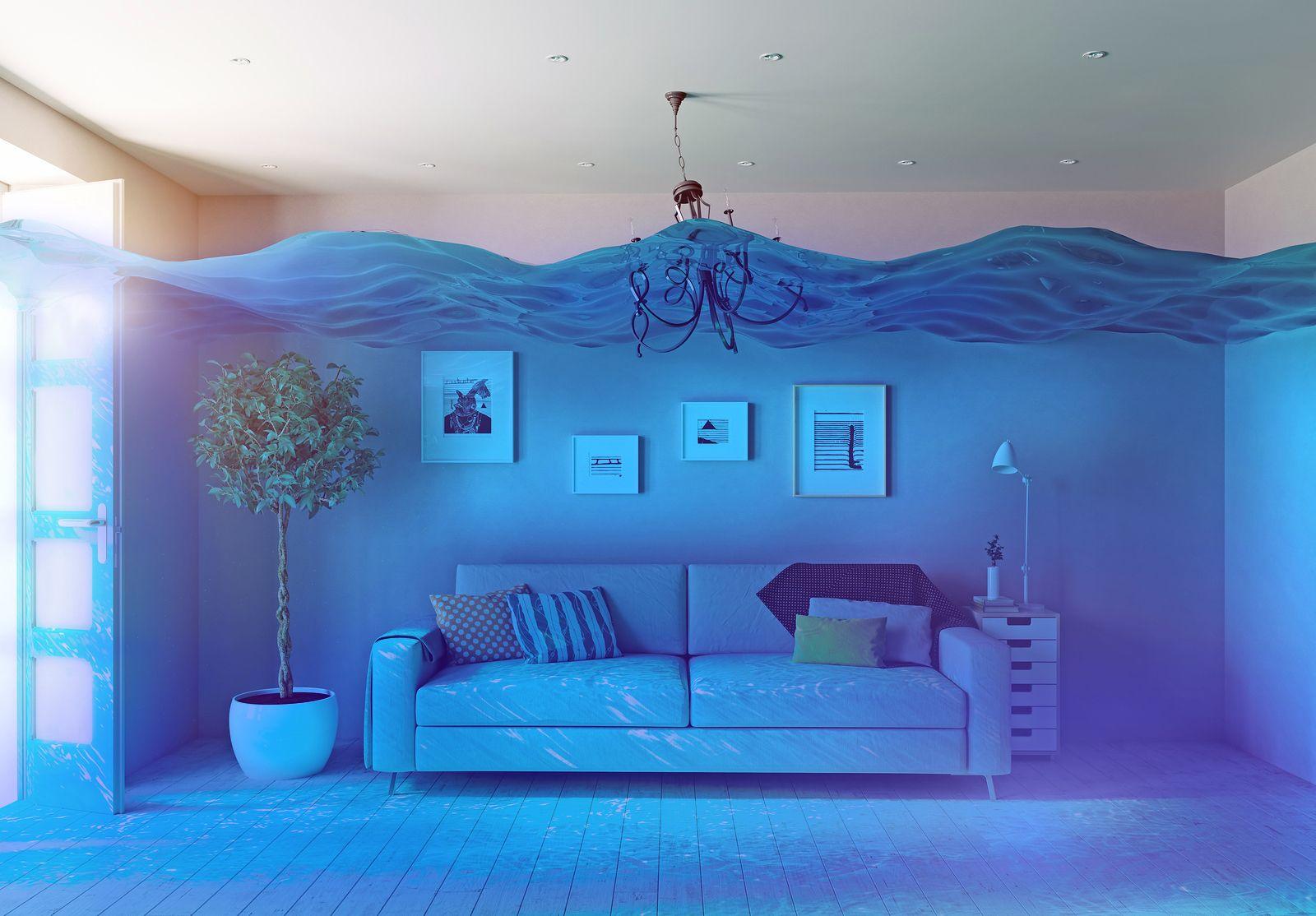 A living room with a couch and a chandelier with water coming out of the ceiling.