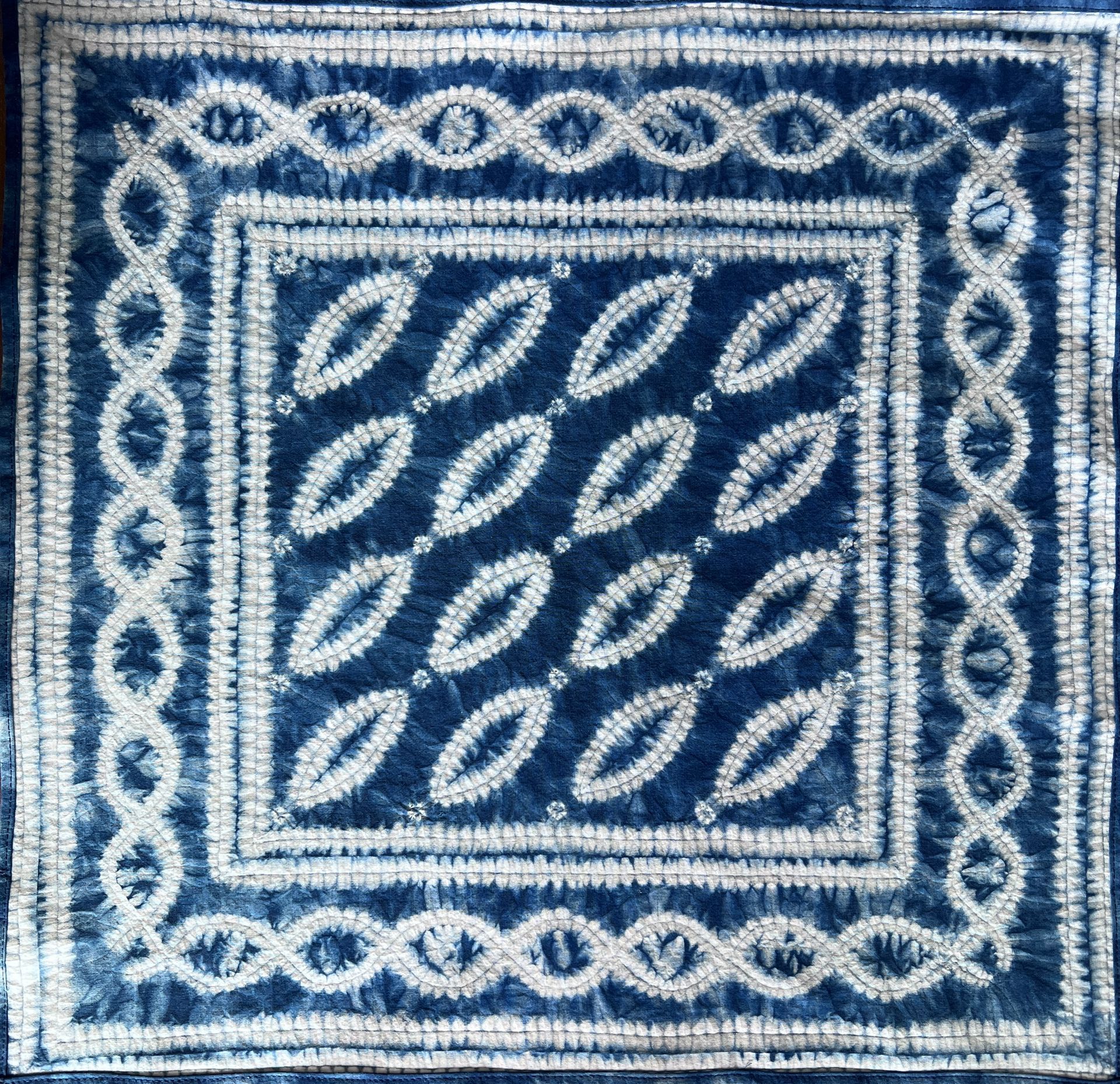 Blue-and-white woven textile with a square leaf and border pattern