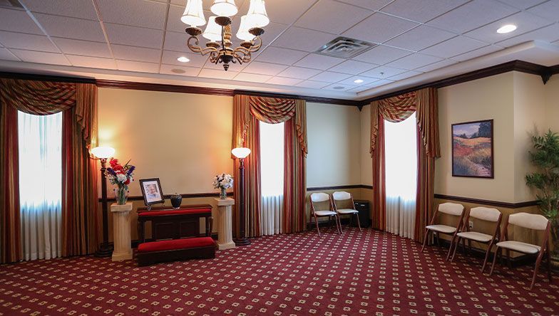 A large room with a red carpet and a chandelier.