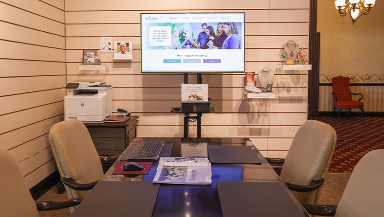 A conference room with a large flat screen tv on the wall.