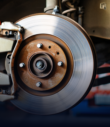 Close-up of a vehicle's disc brake system with a metallic rotor and brake caliper assembly. | Maynard's Auto Repair Service