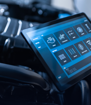 A digital tablet screen displays diagnostic icons and software menus. | Maynard's Auto Repair Service