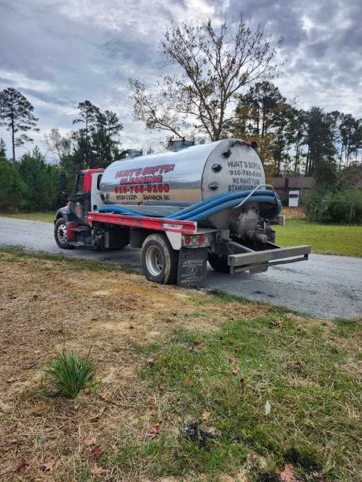 A septic tank truck is parked on the side of the road.