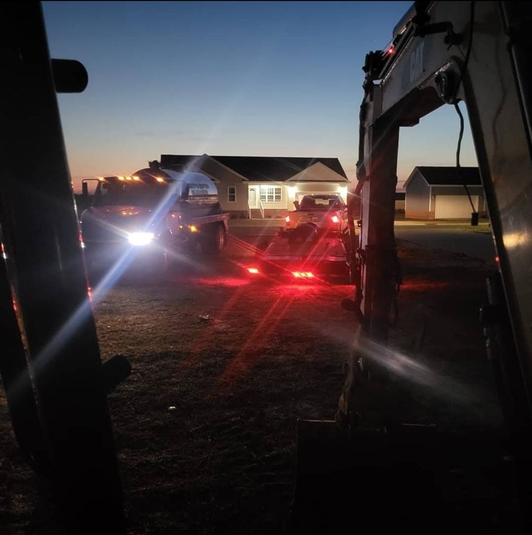 A tow truck is parked in front of a house at night