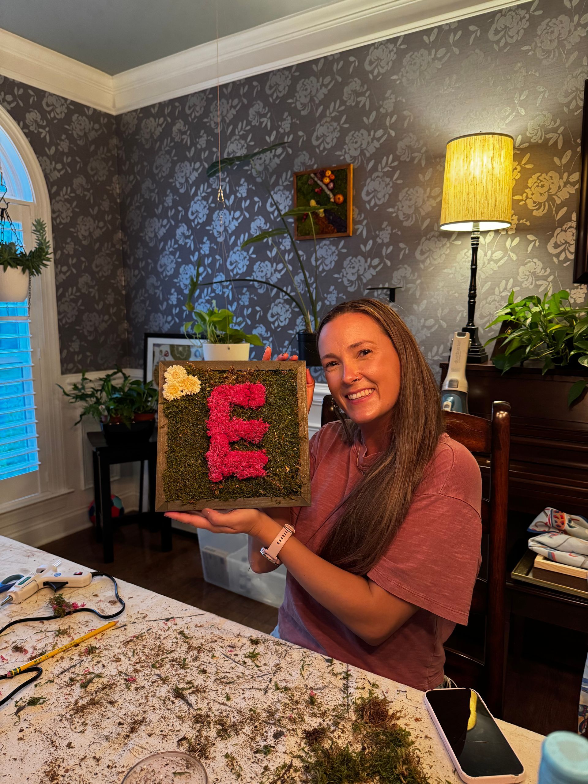Woman holding floral art of the letter