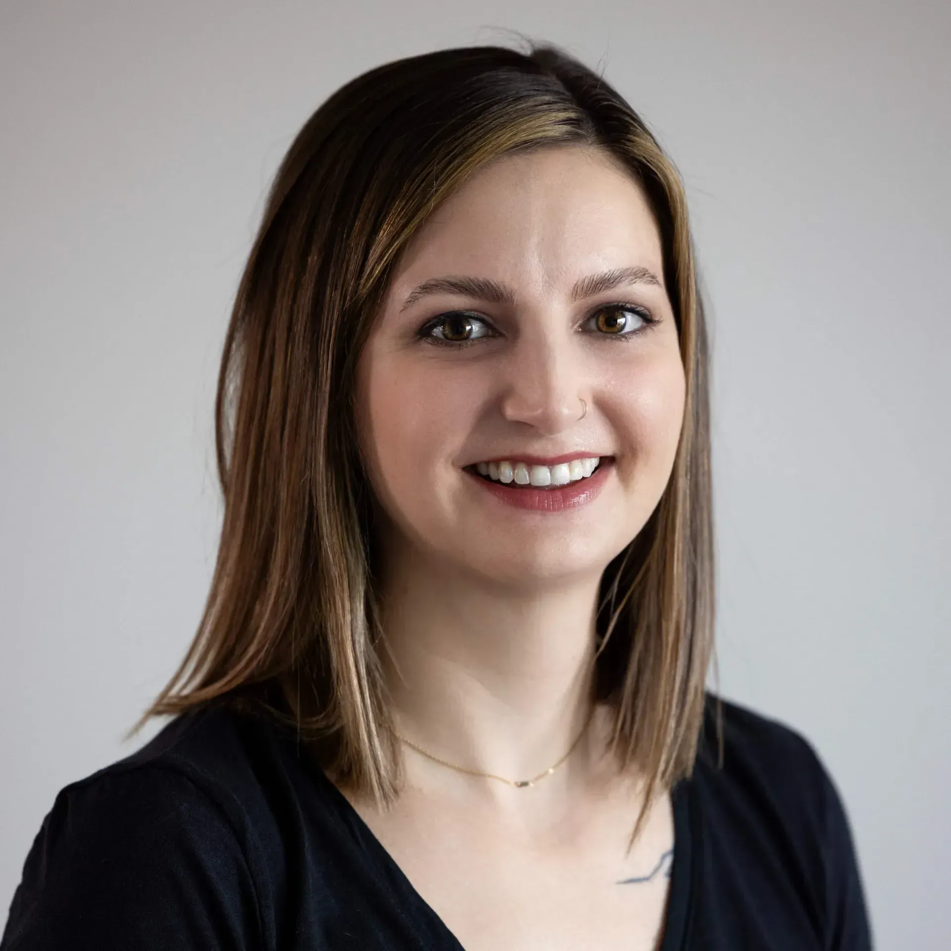 A woman in a black shirt is smiling for the camera.