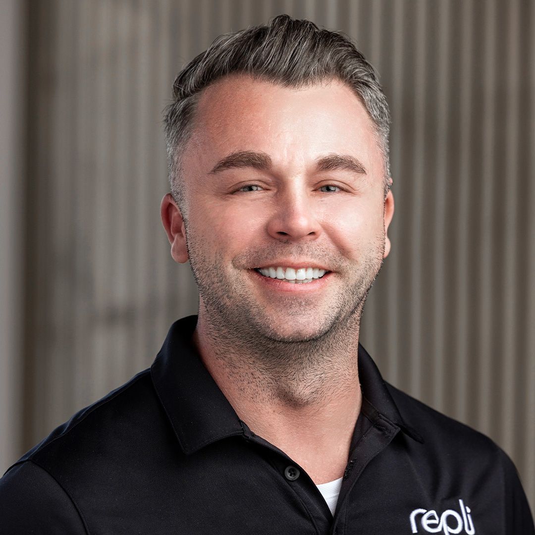 A man wearing a black shirt is smiling for the camera