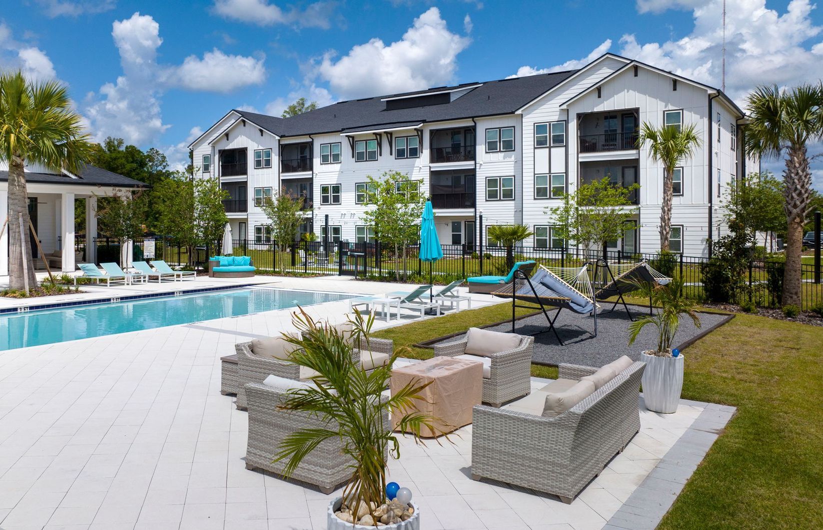 A large white building with a swimming pool in front of it.