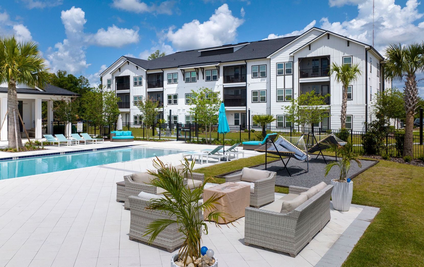 A large white building with a swimming pool in front of it.