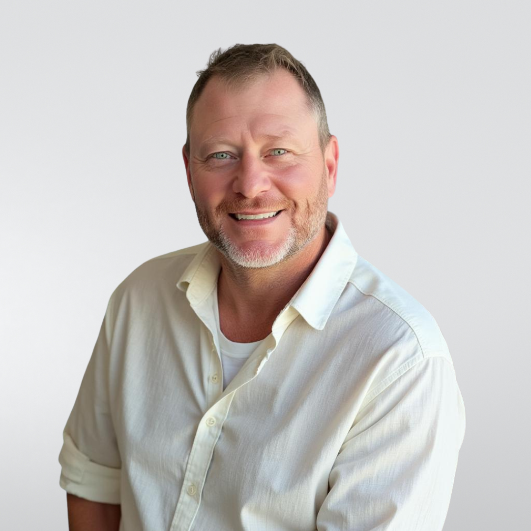 Man smiling, wearing a cream button-down shirt, neutral background.