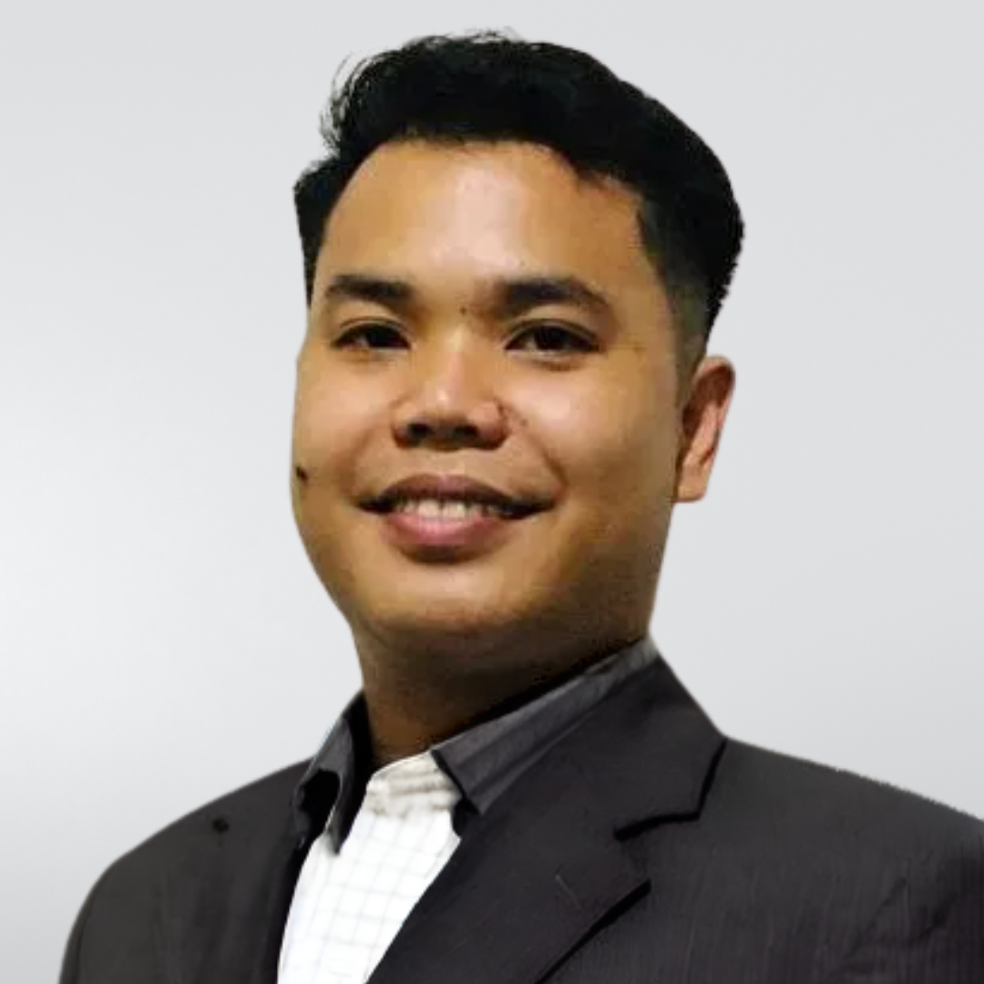 A man in a suit and plaid shirt is smiling for the camera.