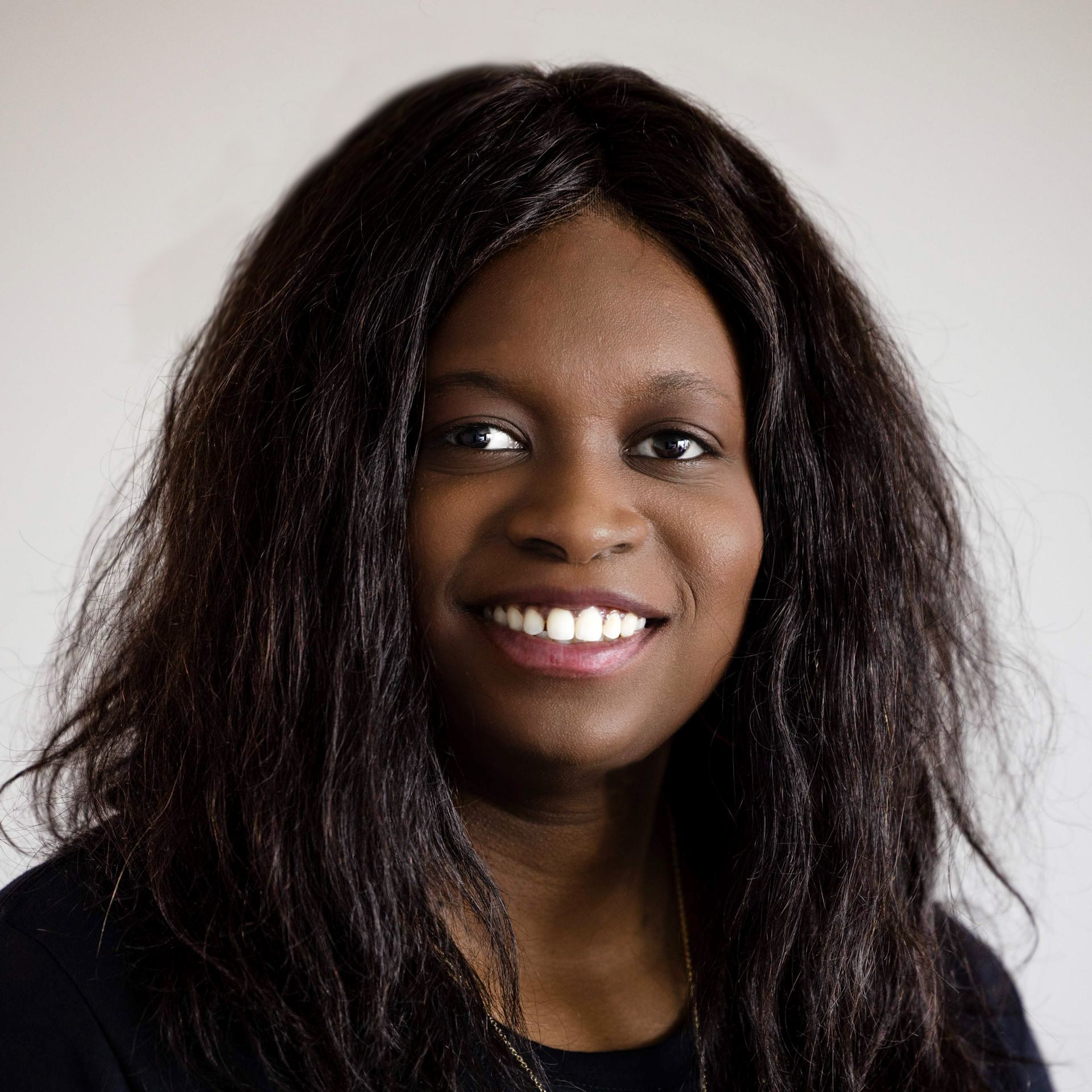 A woman with long dark hair is smiling for the camera.