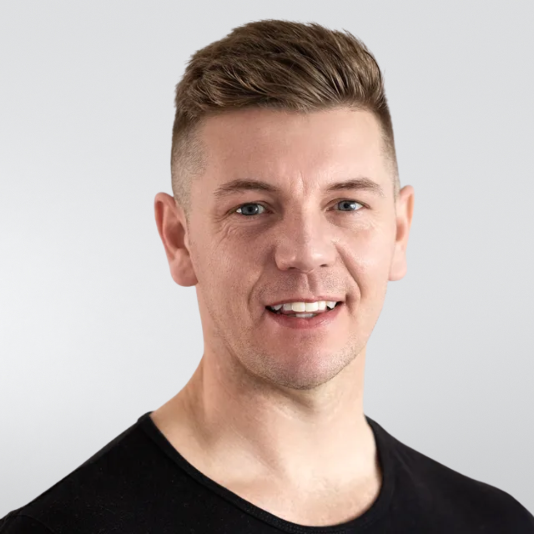 A man in a black shirt is smiling for the camera.