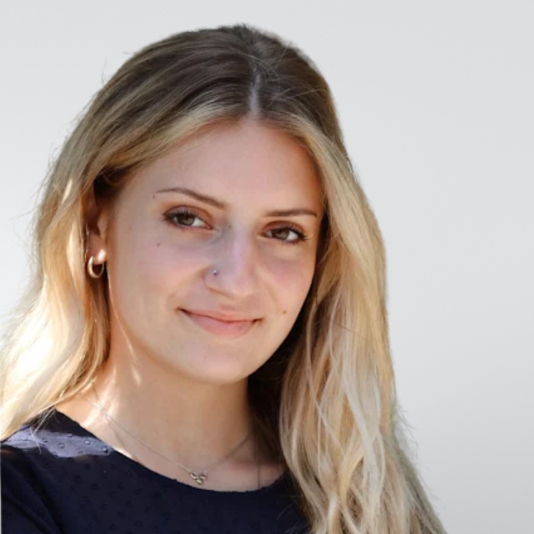 A woman with long blonde hair is smiling for the camera