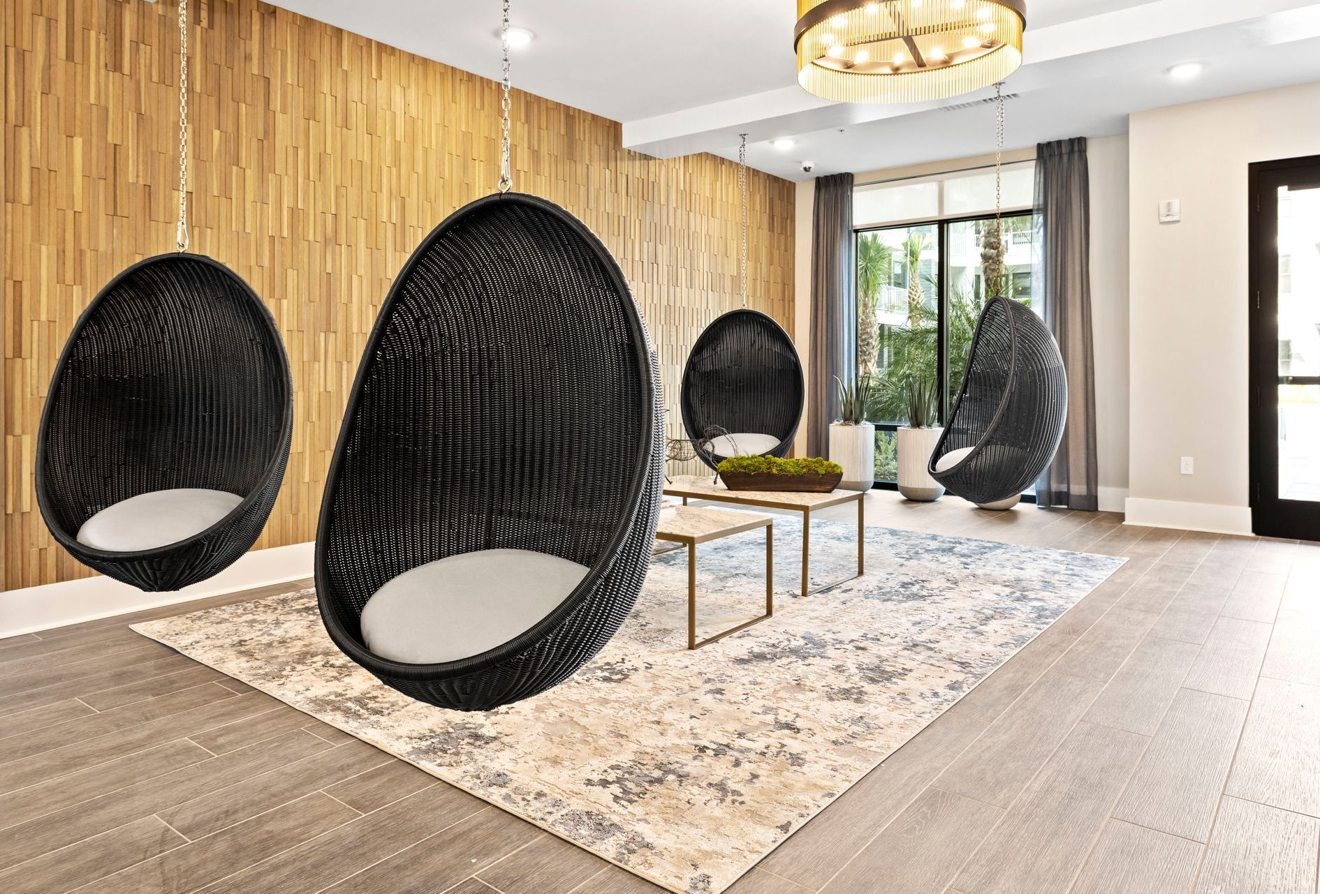 A living room with hanging chairs and a chandelier.