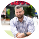 A man with a beard wearing a watch is sitting in a circle.