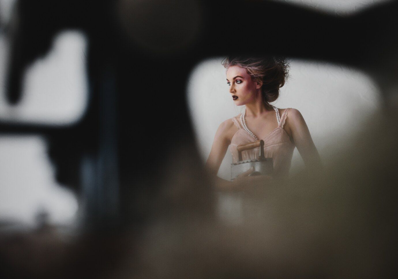 A woman is looking at her reflection in a mirror.