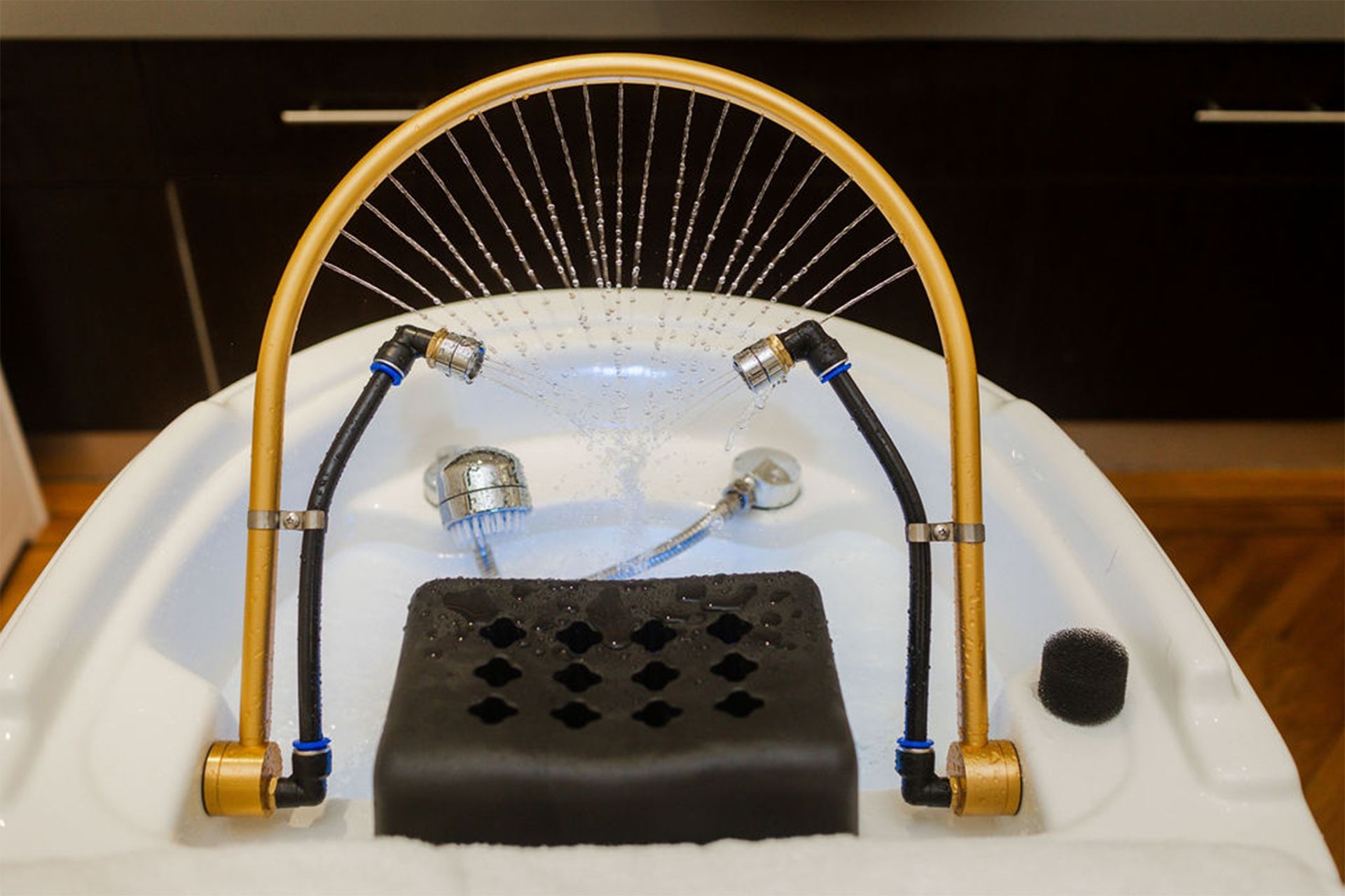 A woman is having a head spa treatment in a sink in a salon.