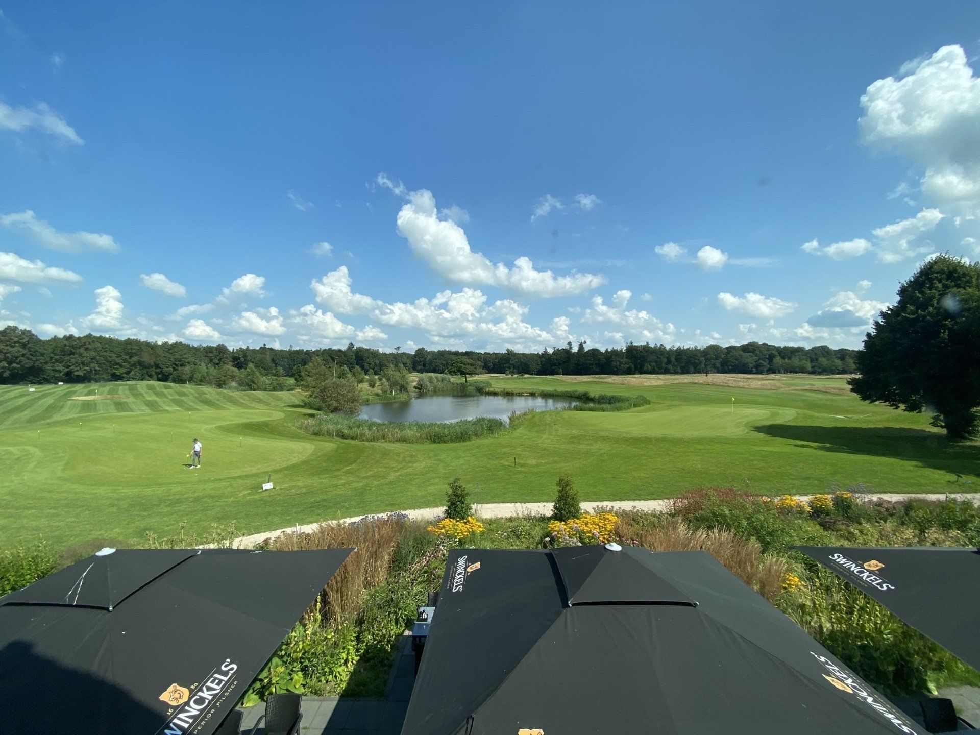 Een uitzicht op een golfbaan met parasols op de voorgrond