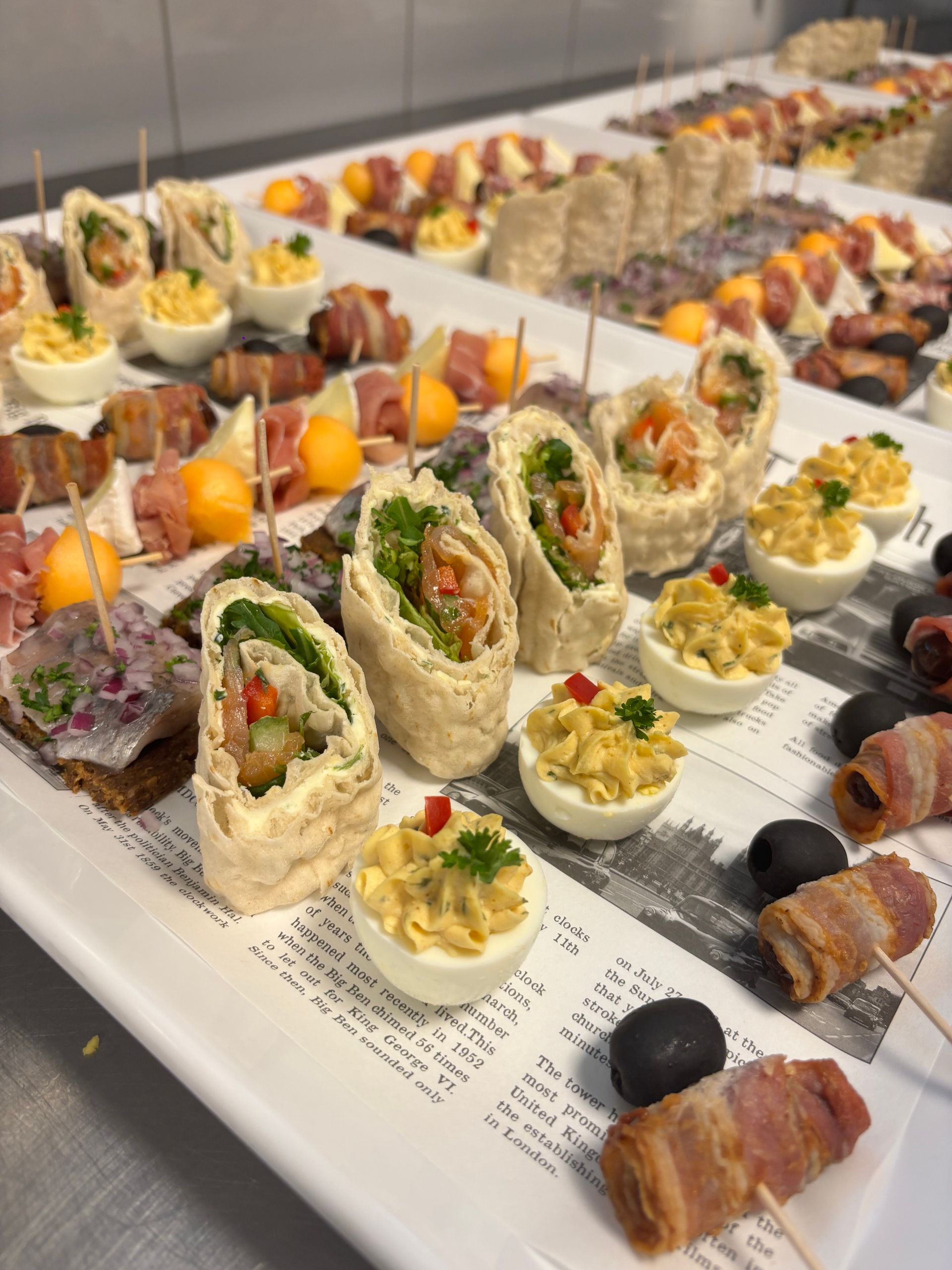 Een persoon houdt een dienblad met eten vast met een shirt waarop herren staat