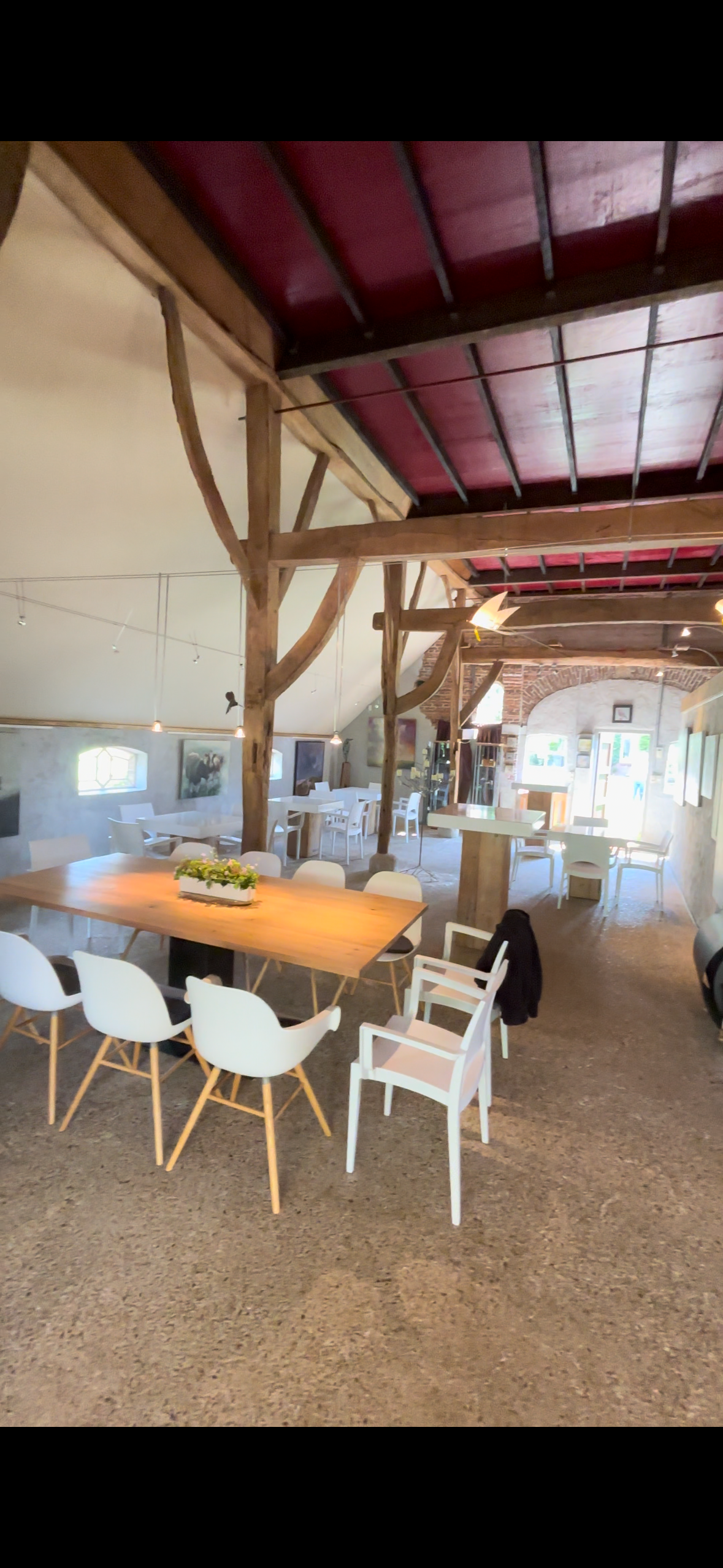 Een grote kamer met een tafel en stoelen.