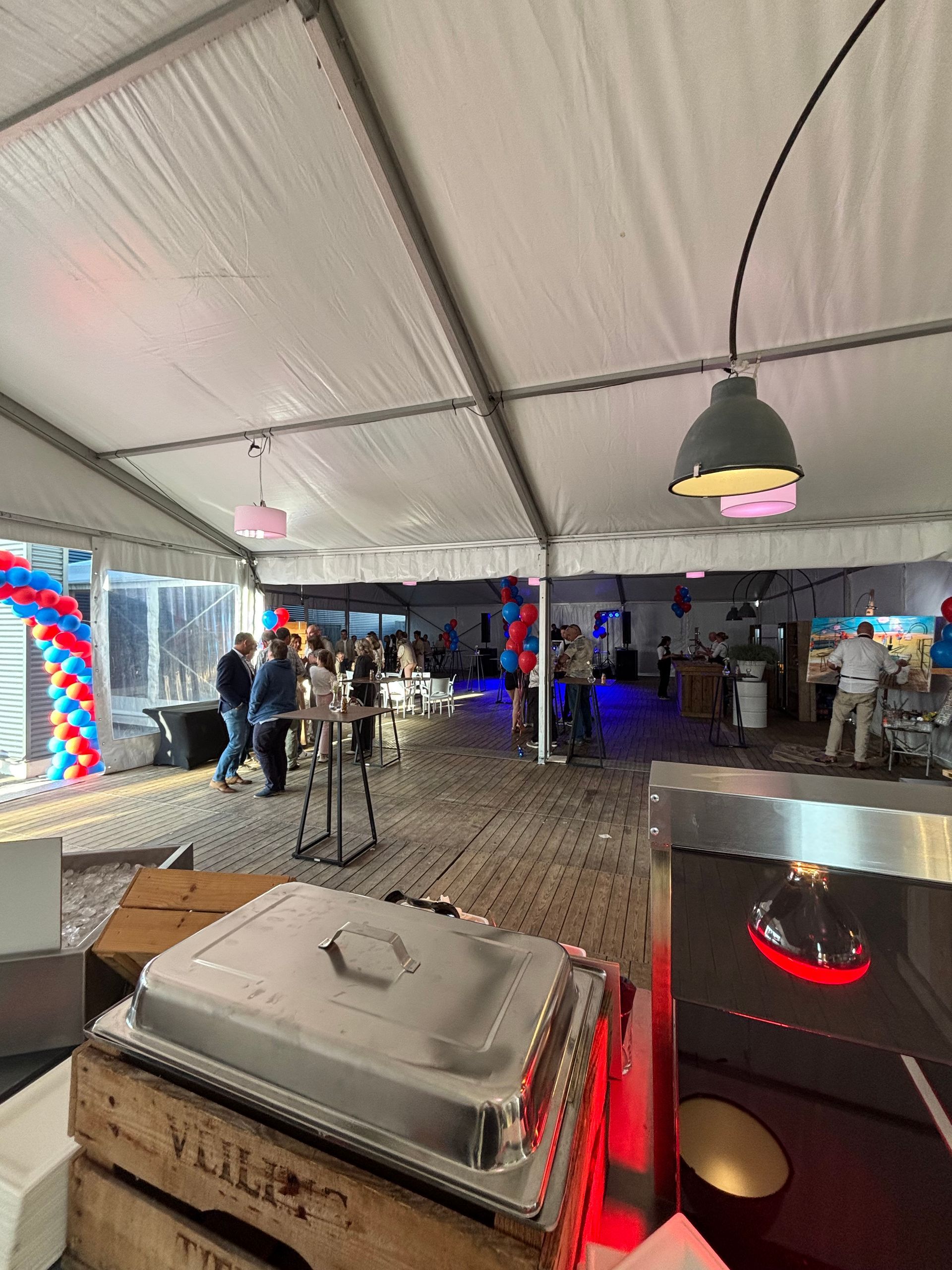 Een grote tent met veel eten en mensen die eromheen staan.