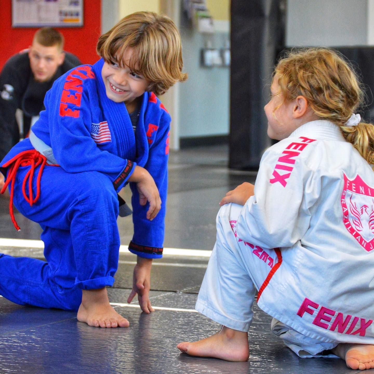 A boy and a girl wearing blue and white kimonos with the word fenix on them