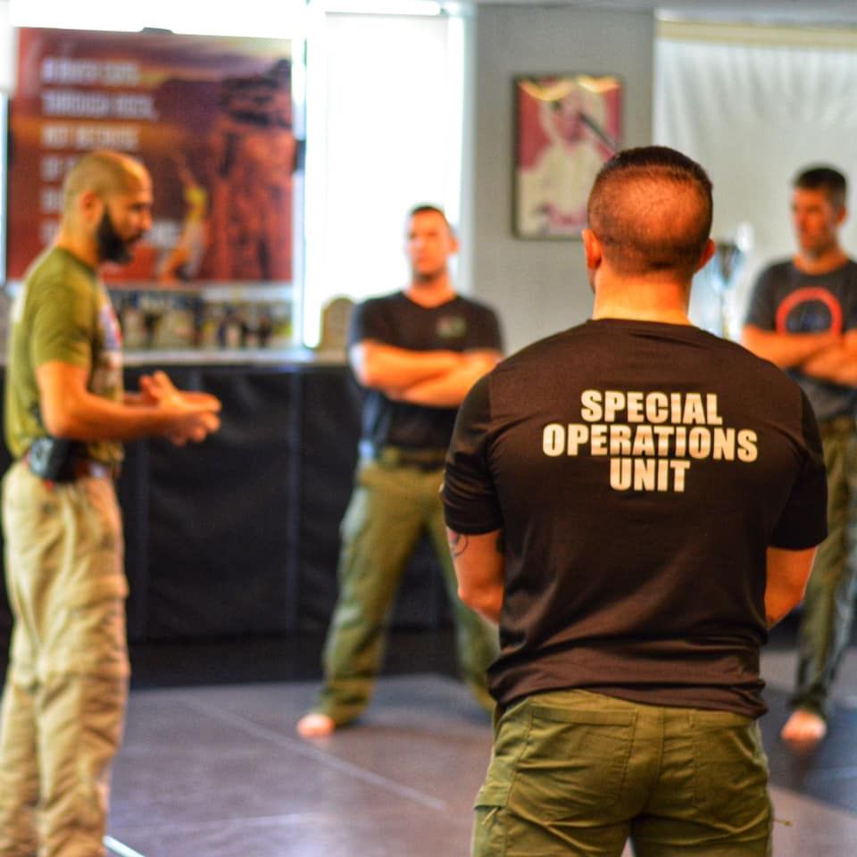 A man is wearing a special operations unit shirt