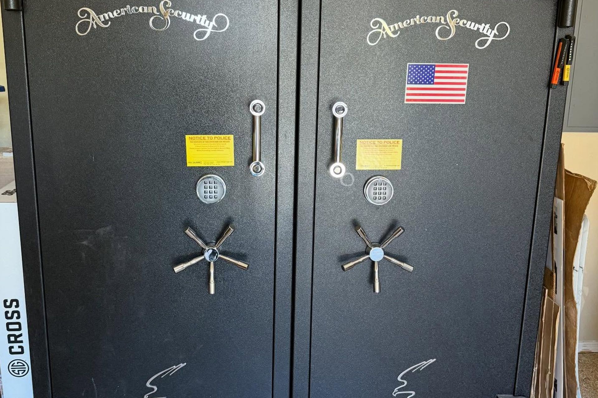 Two black gun safes with chrome handles, keypad locks, and a small American flag decal