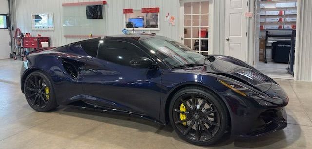 A blue sports car is parked in a garage.