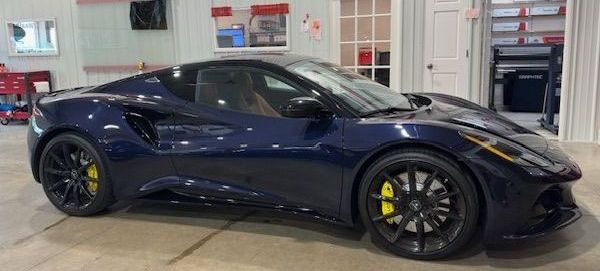 A blue sports car is parked in a garage.
