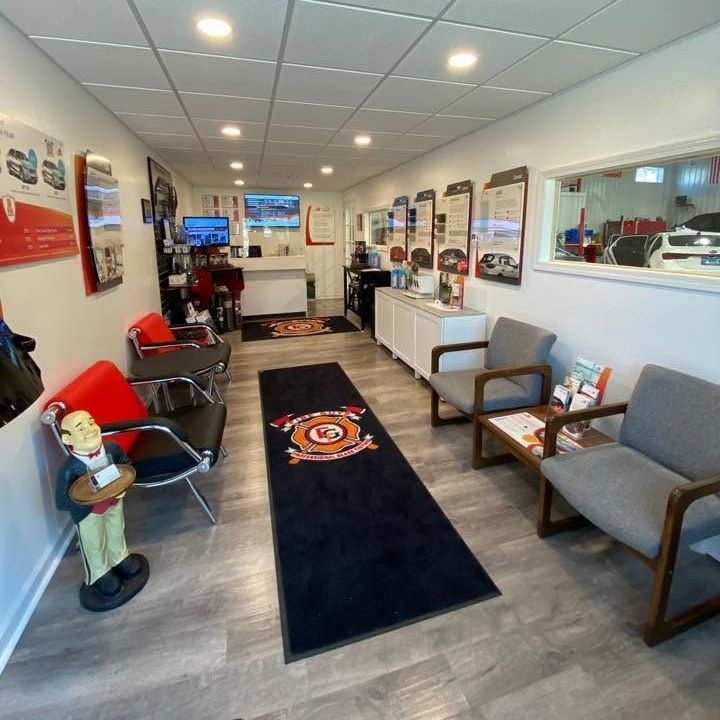 A waiting room in a car dealership with a statue of a man on a table
