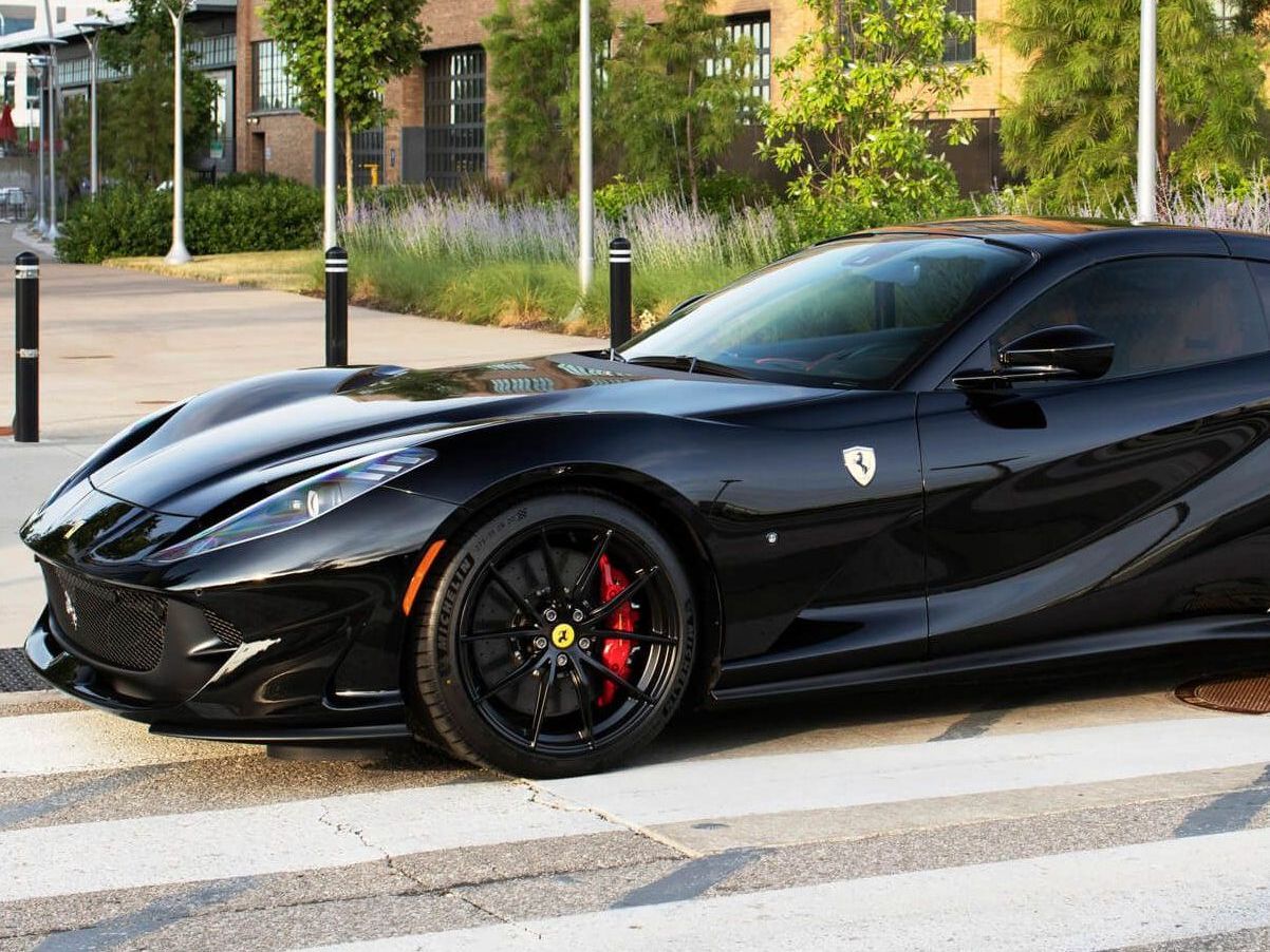 a black sports car is parked in front of a brick building