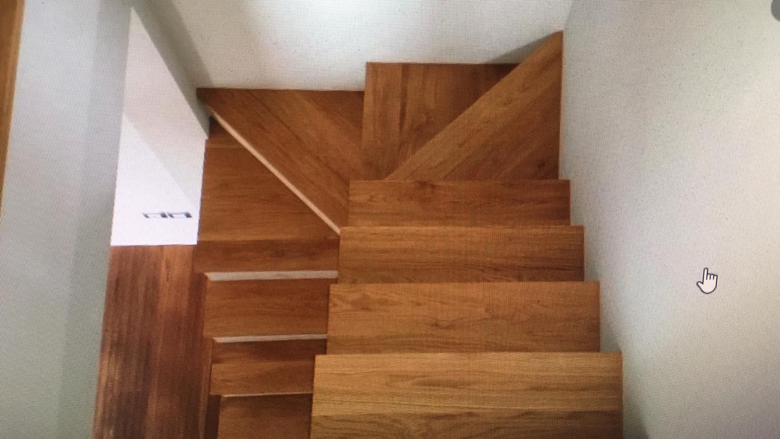 Una scala di legno che porta al secondo piano di una casa.