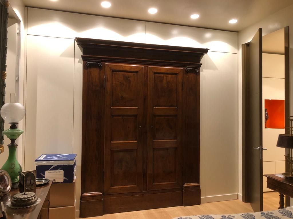 Una camera da letto con un grande armadio in legno nell'angolo