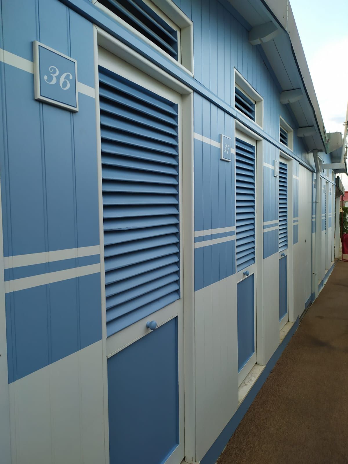 cabine di uno stabilimento balneare blu e bianco con il numero 36 sopra