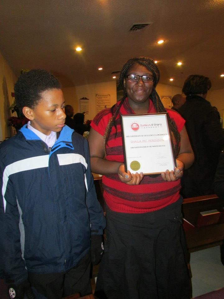 A boy and a woman are standing next to each other holding a certificate