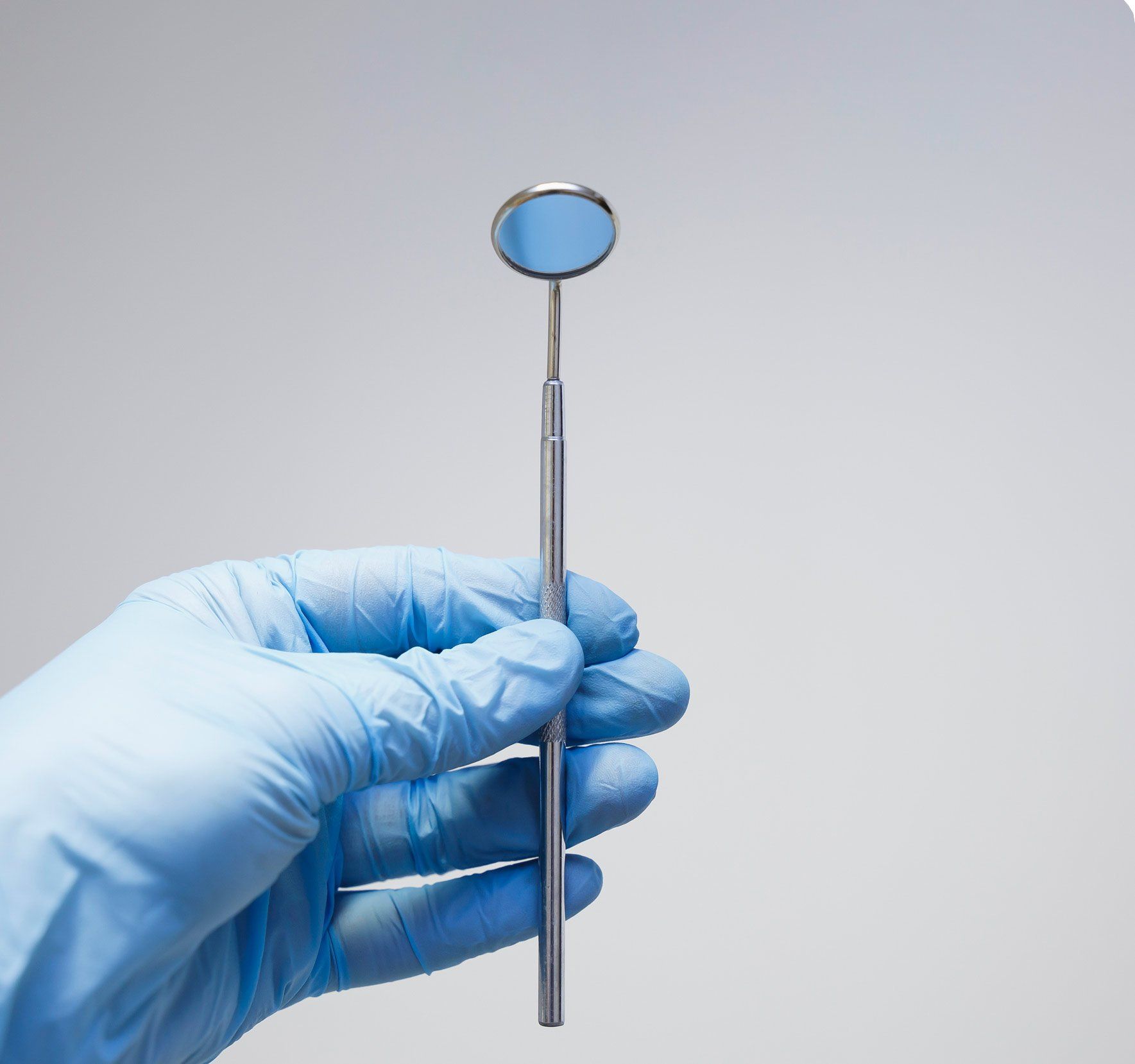 Hand Holding An Angled Mirror — Anchorage, AK — Chinook Family Dentistry