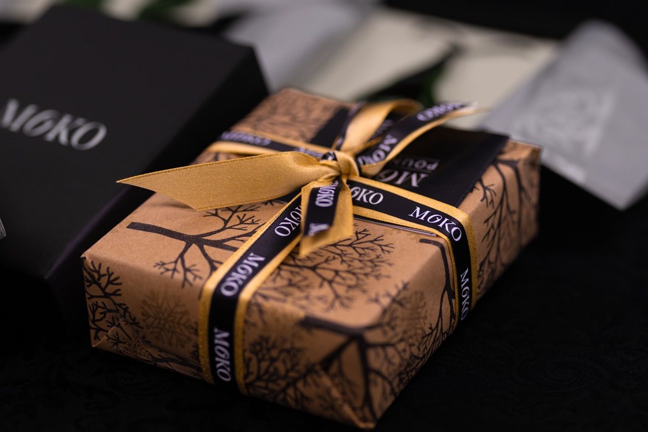 A gift wrapped in brown paper and tied with a gold ribbon