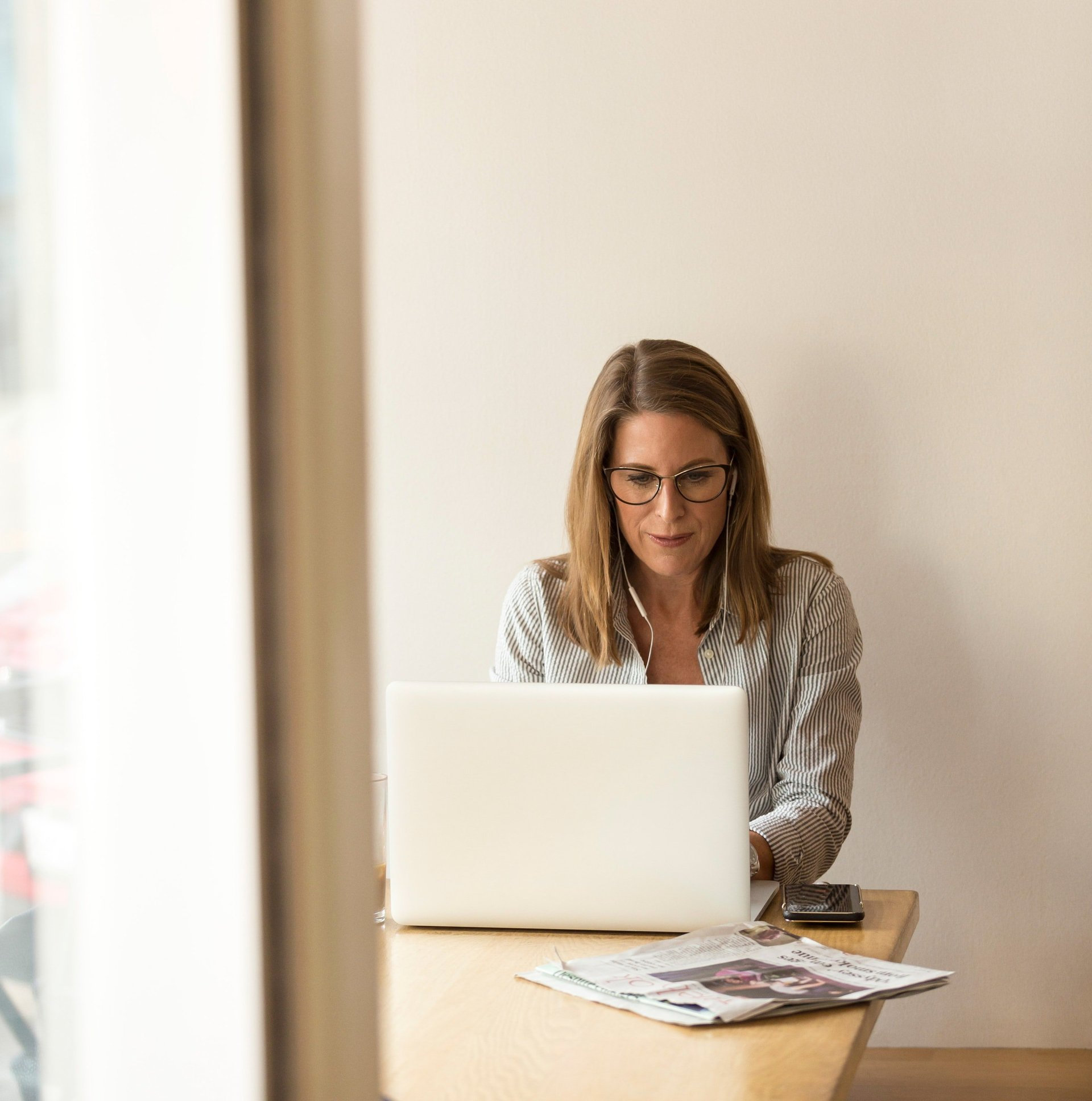 A woman is sitting at a table using a laptop computer.
