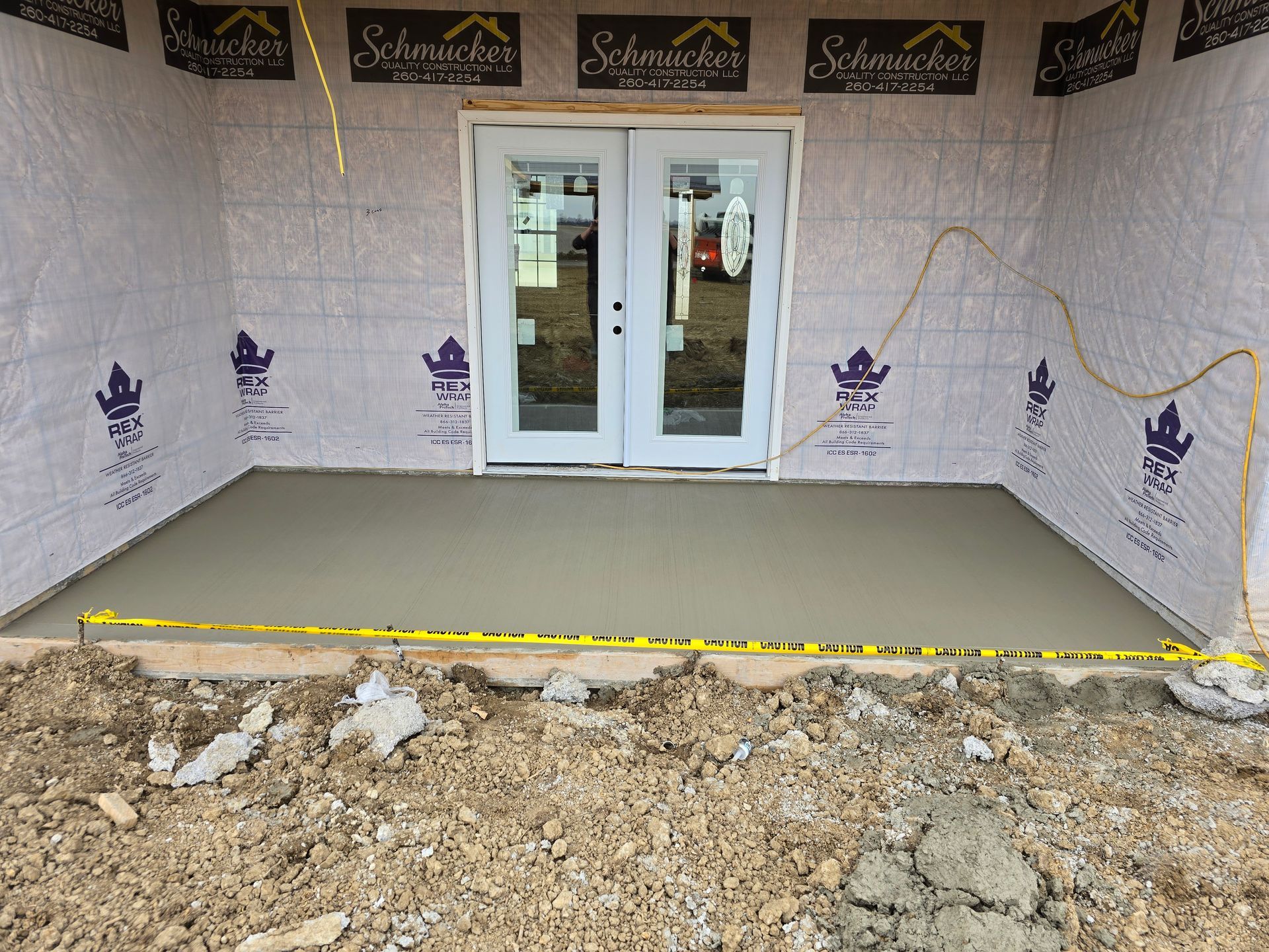 A concrete patio is being built in front of a house